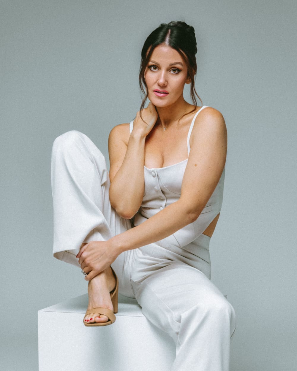 Seated commercial portrait in a white tailored suit